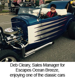 Deb Cleary, Sales Manager for Escapes Ocean Breeze, enjoying one of the classic cars